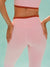 Person wearing pink and brown athletic outfit with 'SET' branding on a teal background