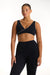 Woman wearing a black sports bra and leggings on a white background <model-info>Jade wears a size L and is 5’9”, 30” waist, 38” bust.</model-info>