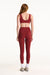 Person wearing a red sports bra and leggings set on a white background