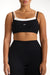 Black sports bra with white straps worn by a person on a white background