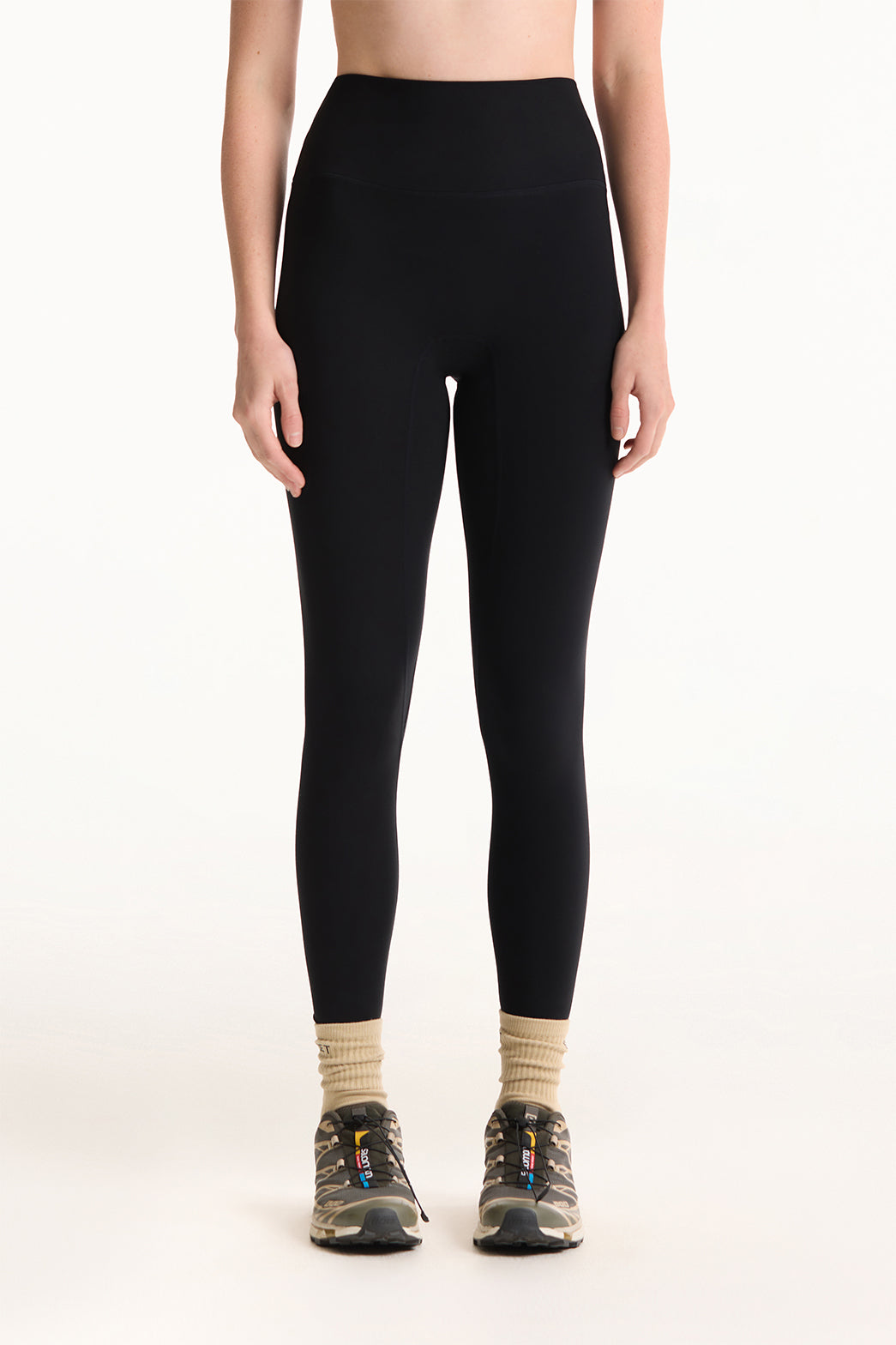 Person wearing black leggings on a white background 