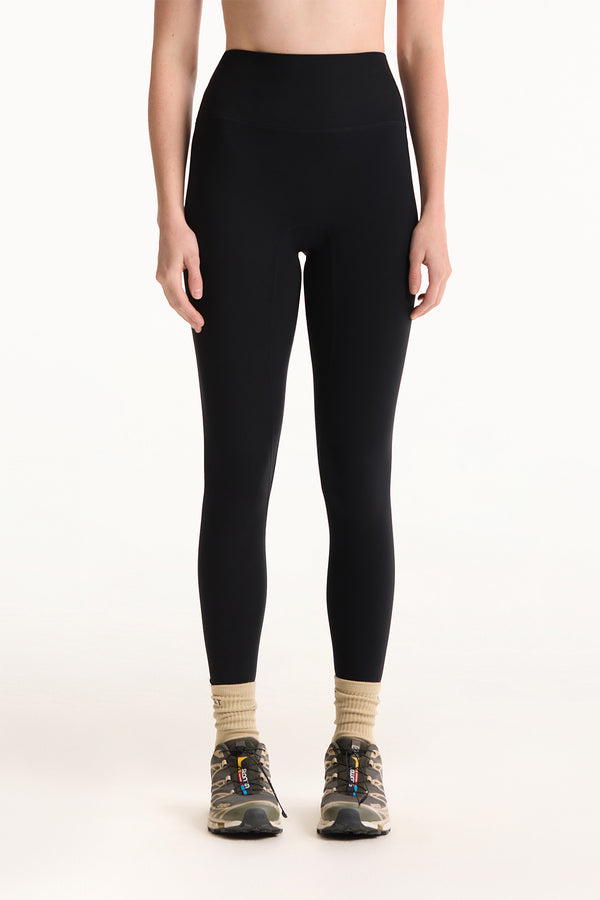 Person wearing black leggings on a white background 