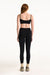 Person wearing a black sports bra and leggings set on a white background