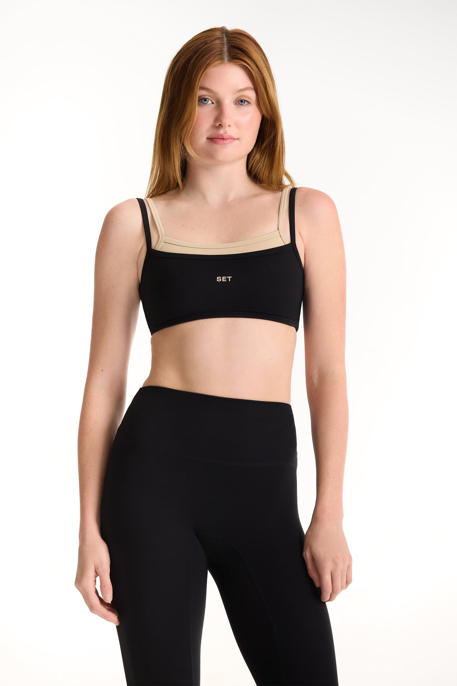 Woman wearing a black sports bra and leggings on a white background <model-info>Dickey wears a size S and is 5’9”, 24” waist, 32” bust.</model-info>