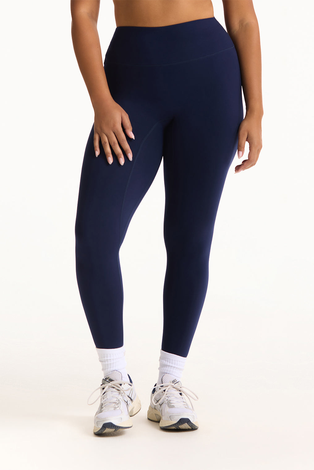 Person wearing navy blue leggings on a white background <model-info>Jade wears a size L and is 5’9”, 30” waist, 38” bust.</model-info>
