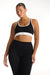 Woman wearing a black sports bra and leggings with a white brand logo on a white background <model-info>Jade wears a size L and is 5’9”, 30” waist, 38” bust.</model-info>