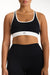 Black sports bra with white accents worn by a person on a plain background