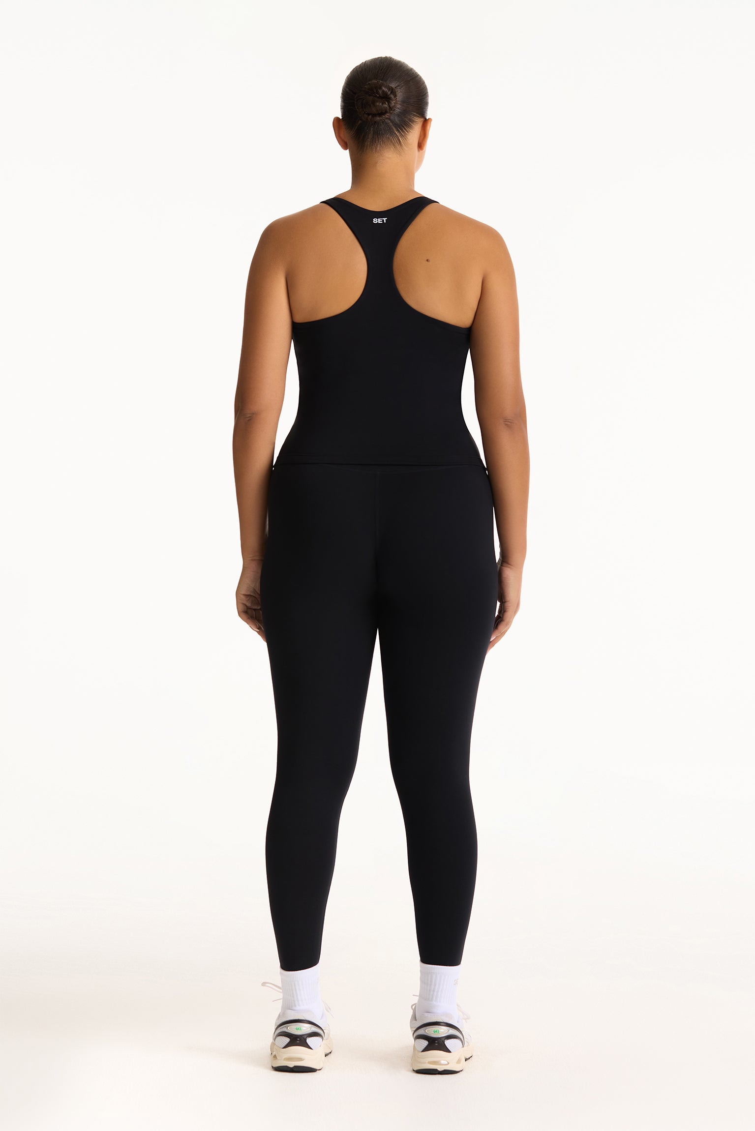 Person wearing a black athletic outfit on a white background