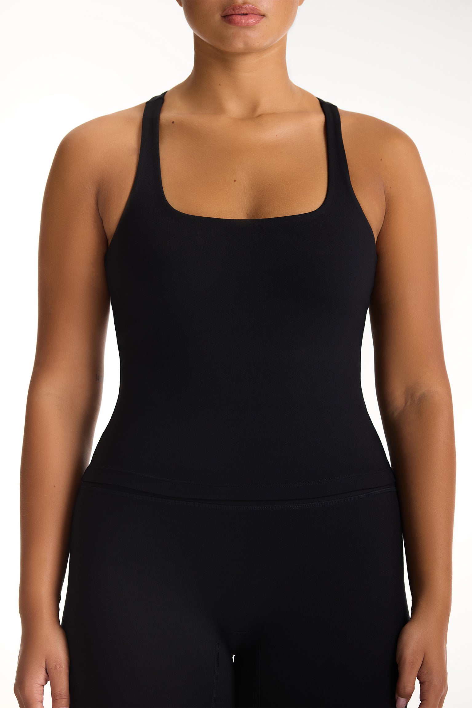 Black tank top worn by a person on a white background