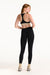 Woman wearing a black sports bra and leggings on a white background
