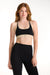 Woman wearing a black sports bra and leggings on a white background <model-info>Dickey wears a size S and is 5’9”, 24” waist, 32” bust.</model-info>