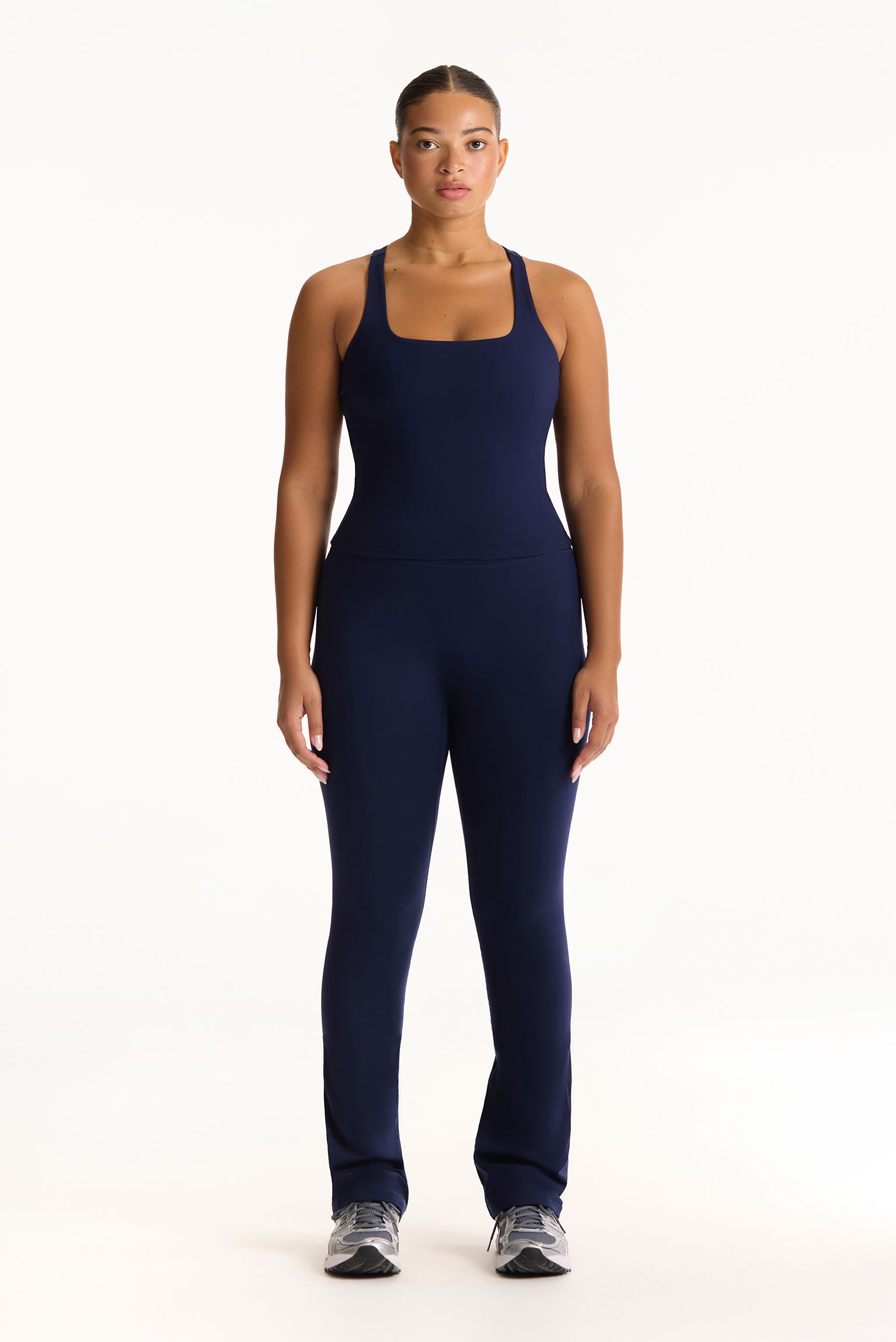 Woman wearing a navy blue athletic outfit on a white background