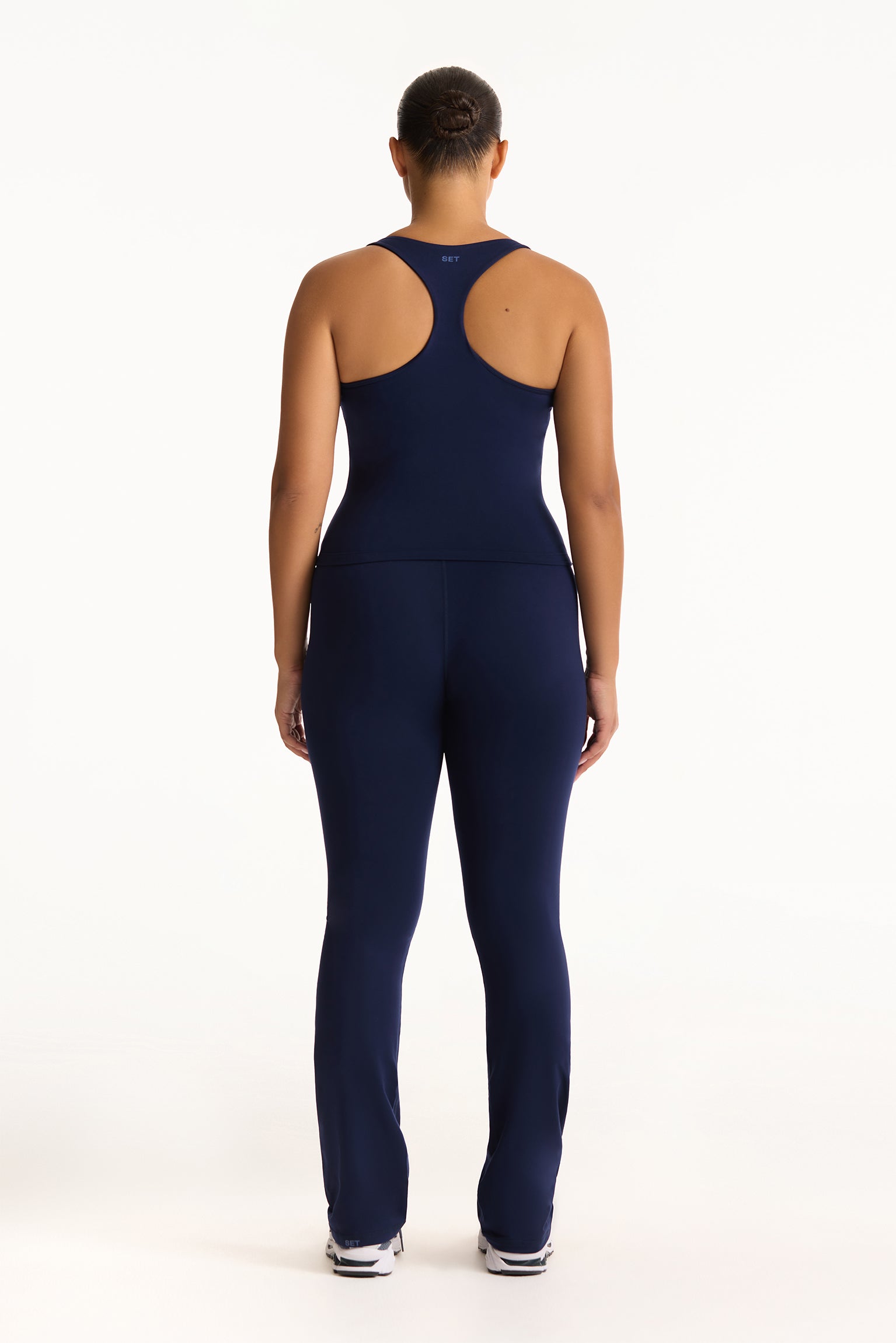 Person wearing a navy blue athletic outfit on a white background