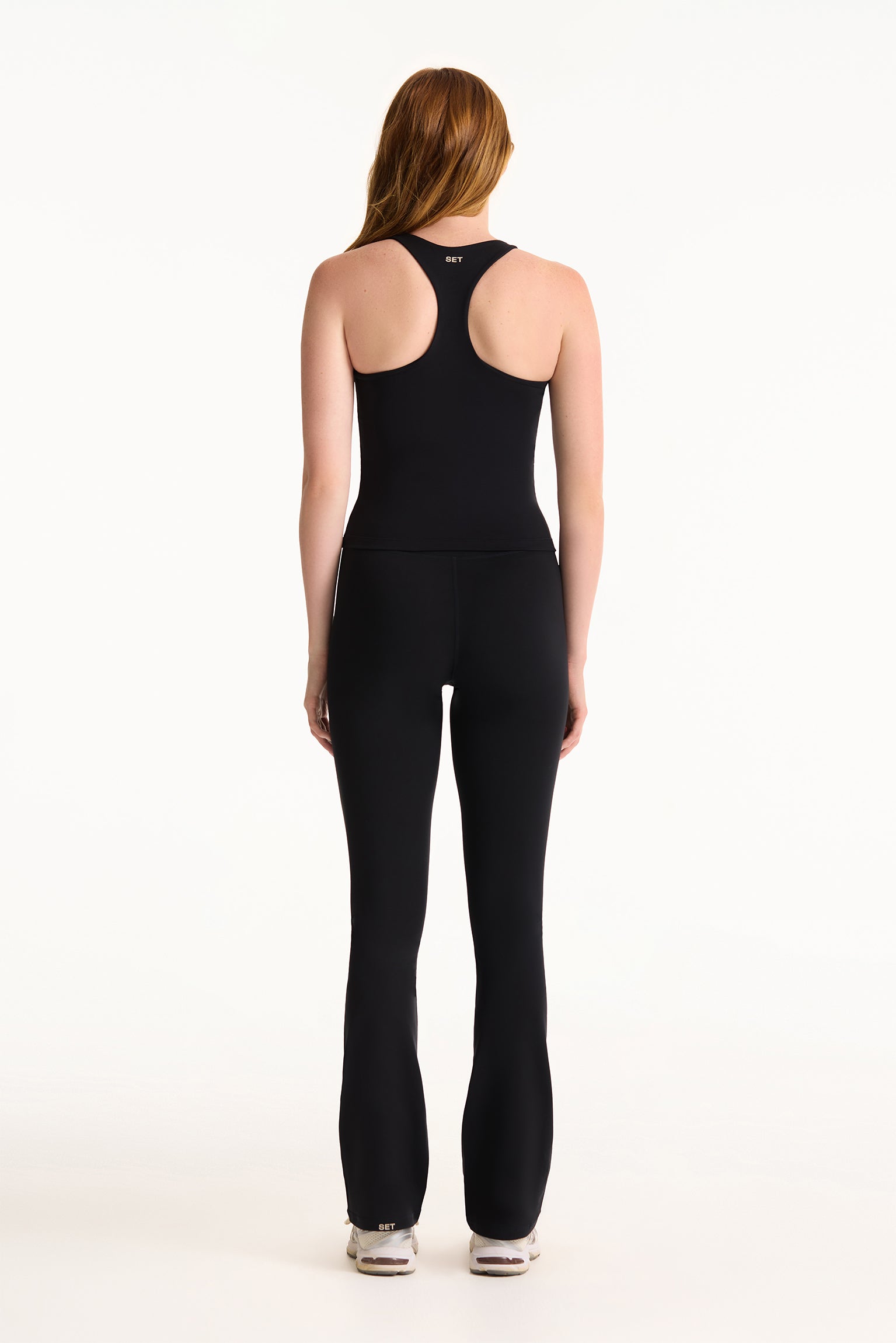 Woman wearing black activewear set on white background