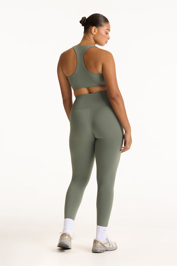 Woman wearing a green athletic outfit on a white background