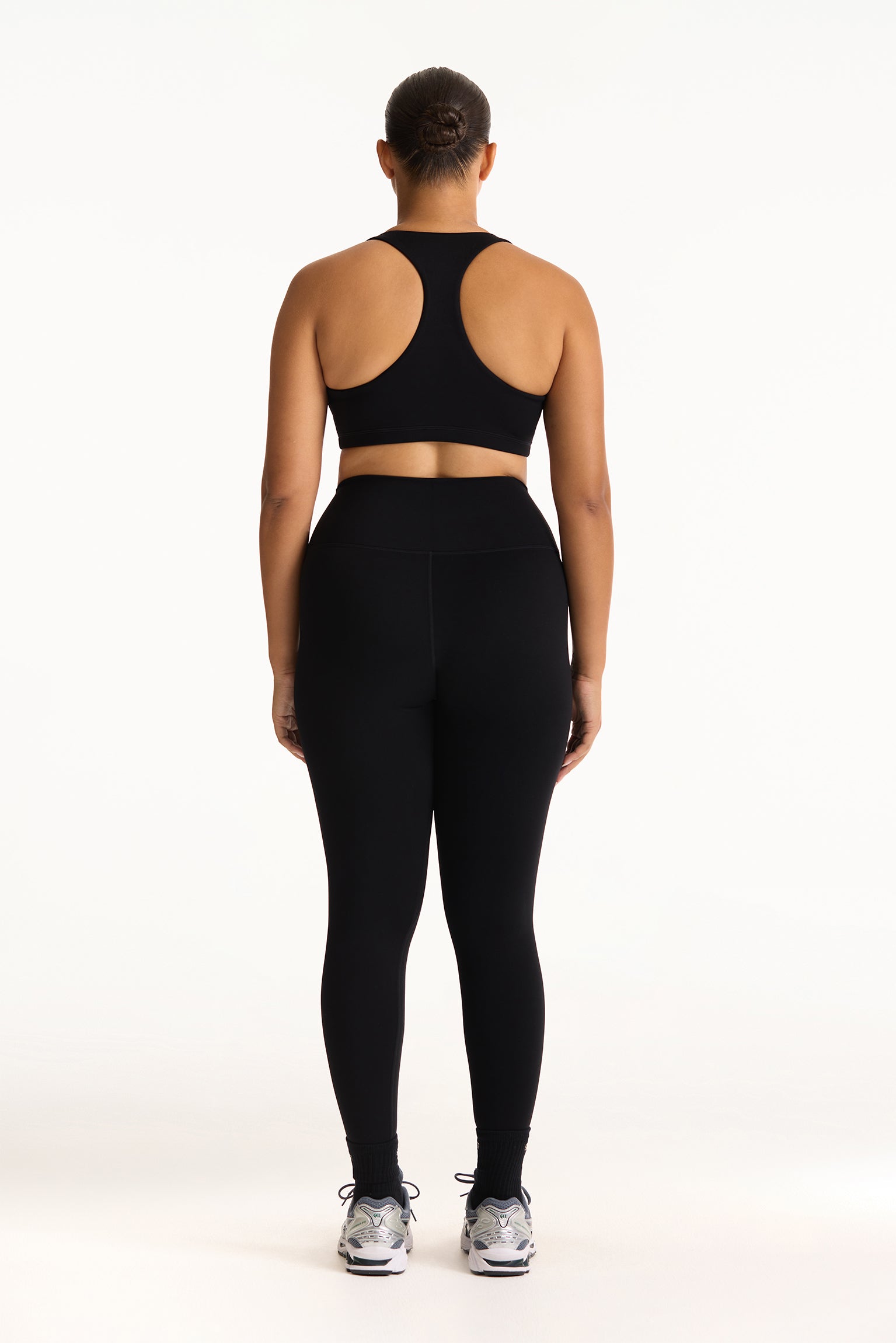 Person wearing a black athletic outfit on a white background