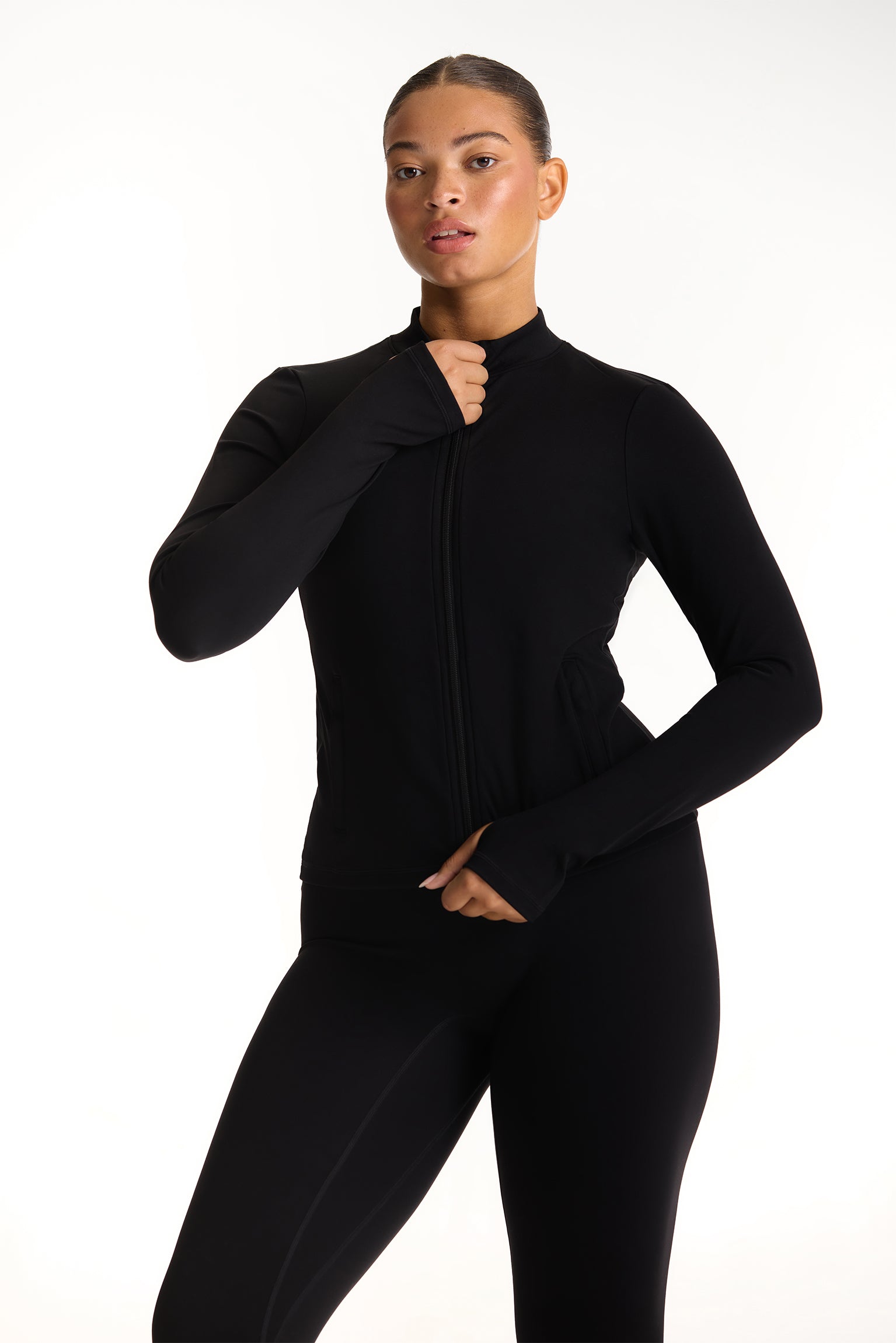 Person wearing a black full-body suit on a white background 