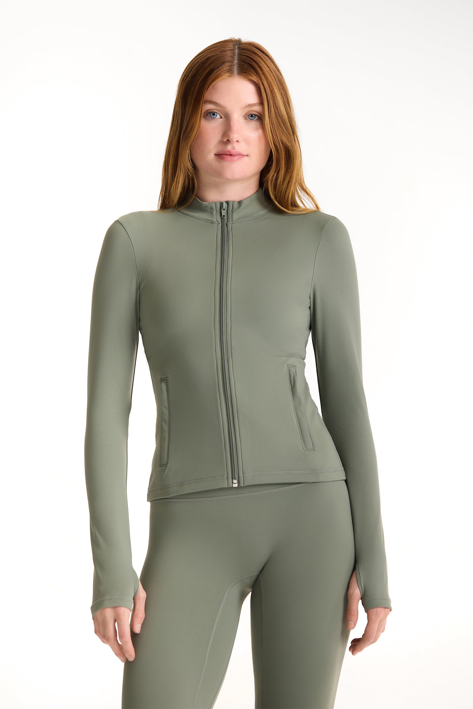 Woman wearing a green athletic jacket and leggings on a white background <model-info>Dickey wears a size S and is 5’9”, 24” waist, 32” bust.</model-info>