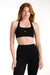 Woman wearing a black sports bra and leggings on a white background <model-info>Dickey wears a size S and is 5’9”, 24” waist, 32” bust.</model-info>