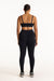 Person wearing a black sports bra and leggings set on a white background