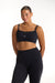 Woman wearing a black sports bra and leggings on a white background <model-info>Jade wears a size L and is 5’9”, 30” waist, 38” bust.</model-info>