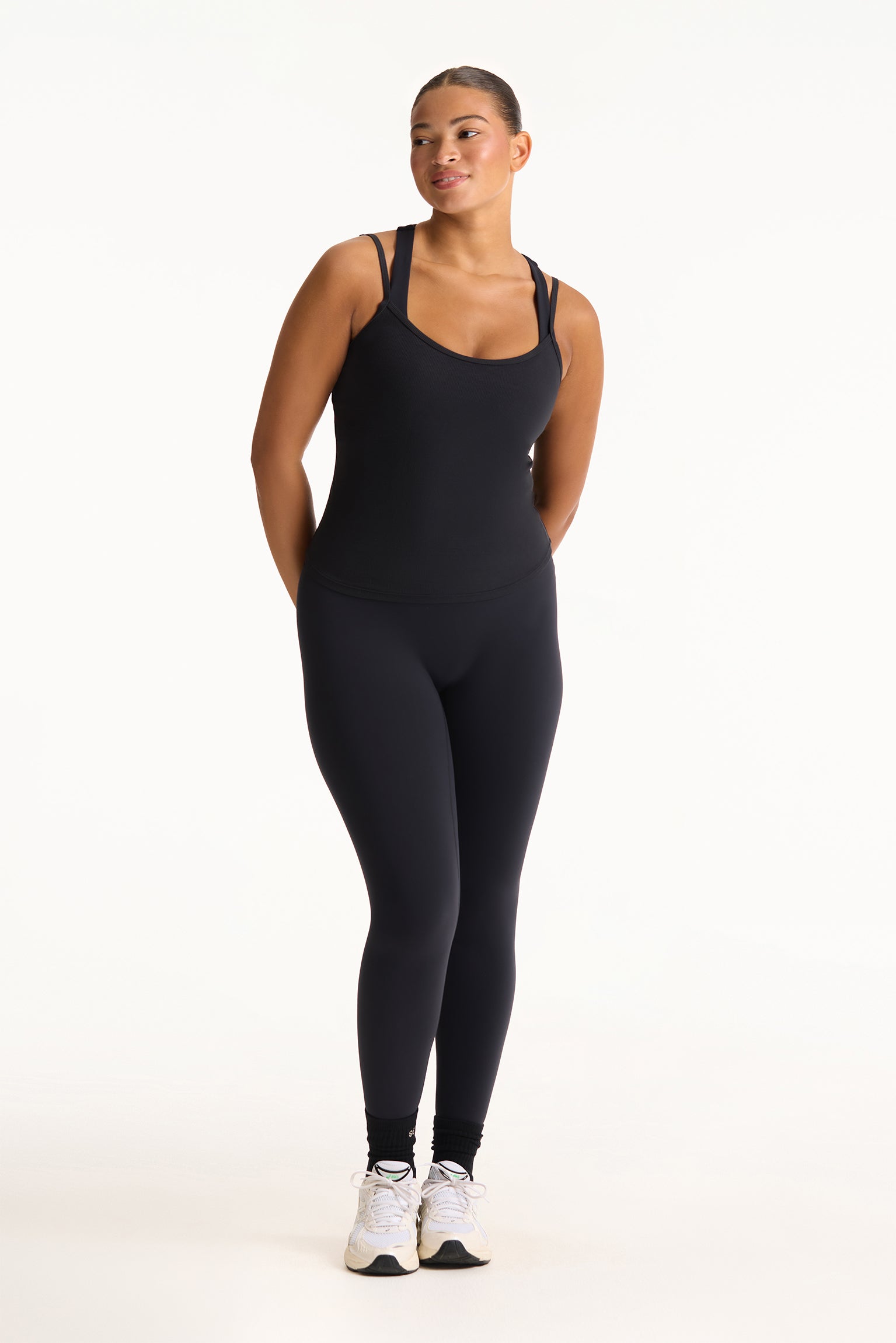 Woman wearing a black bodysuit on a white background