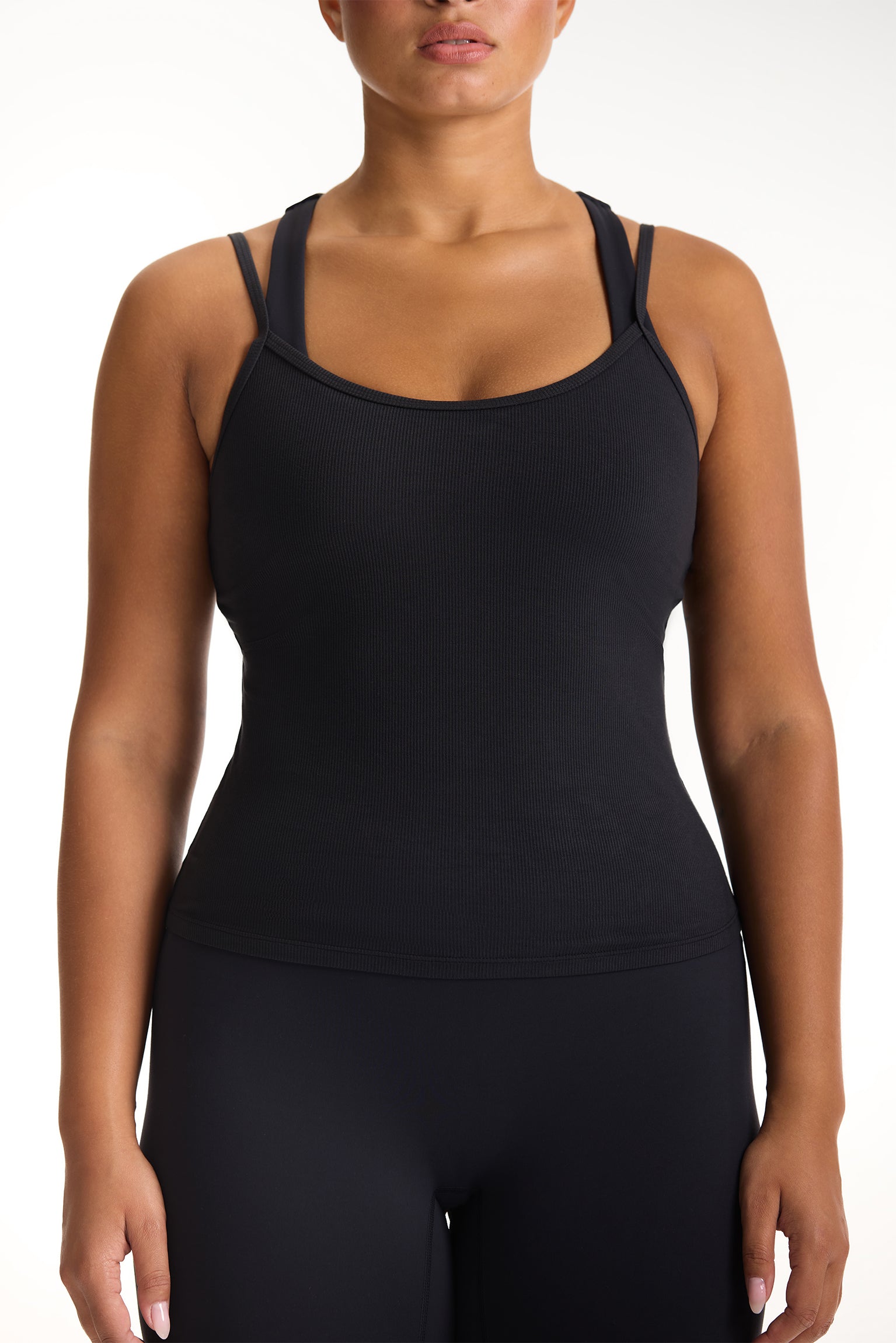 Black tank top worn by a person on a white background