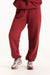 Red sweatpants worn with gray sneakers on a white background <model-info>Jade wears a size L and is 5’9”, 30” waist, 38” bust.</model-info>
