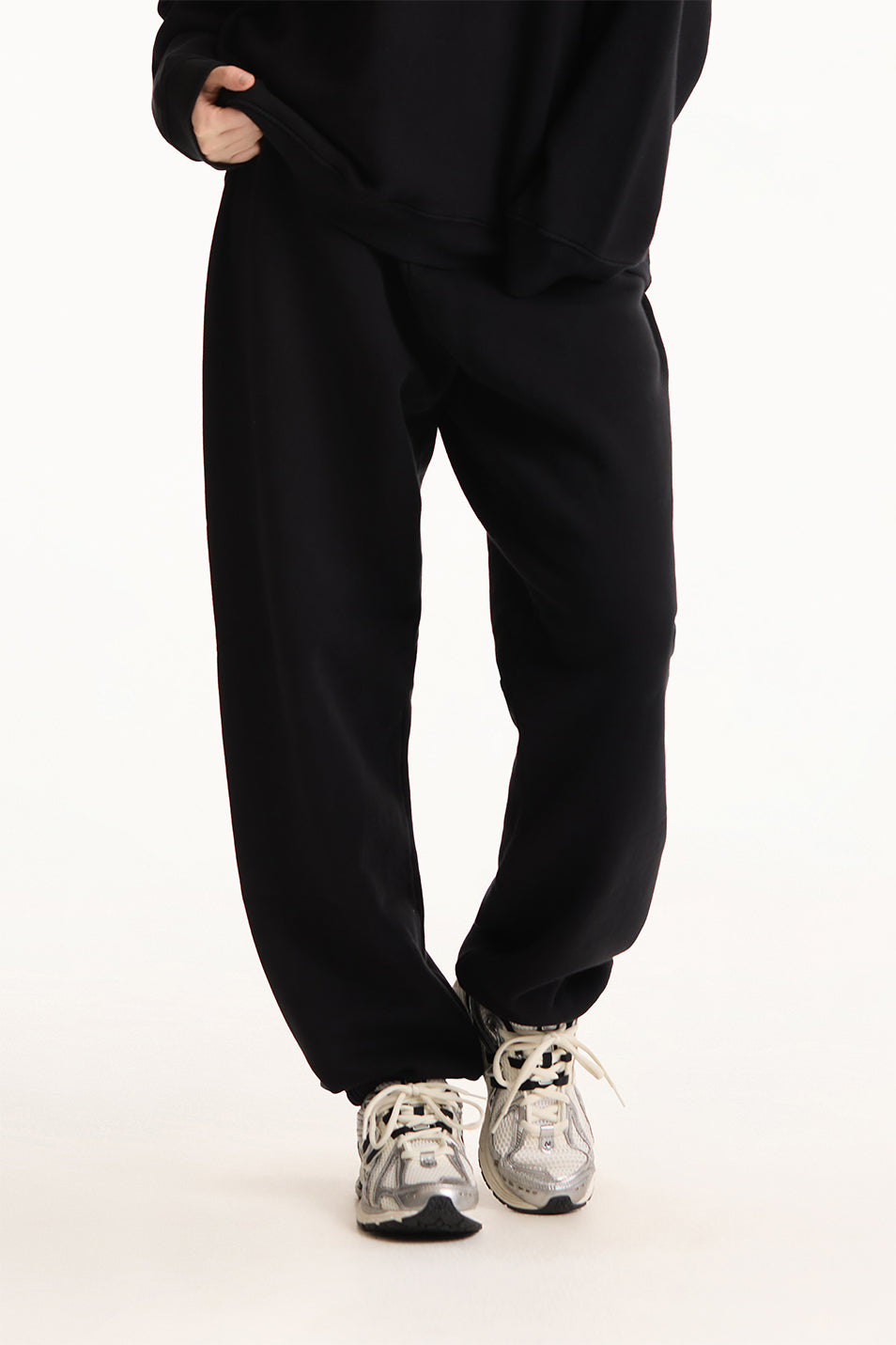 Person wearing black pants and white sneakers on a white background <model-info>Dickey wears a size L and is 5’9”, 24” waist, 32” bust.</model-info>