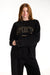 Person wearing a black sweatshirt with 'SET Sport' text on a white background <model-info>Dickey wears a size M and is 5’9”, 24” waist, 32” bust.</model-info>