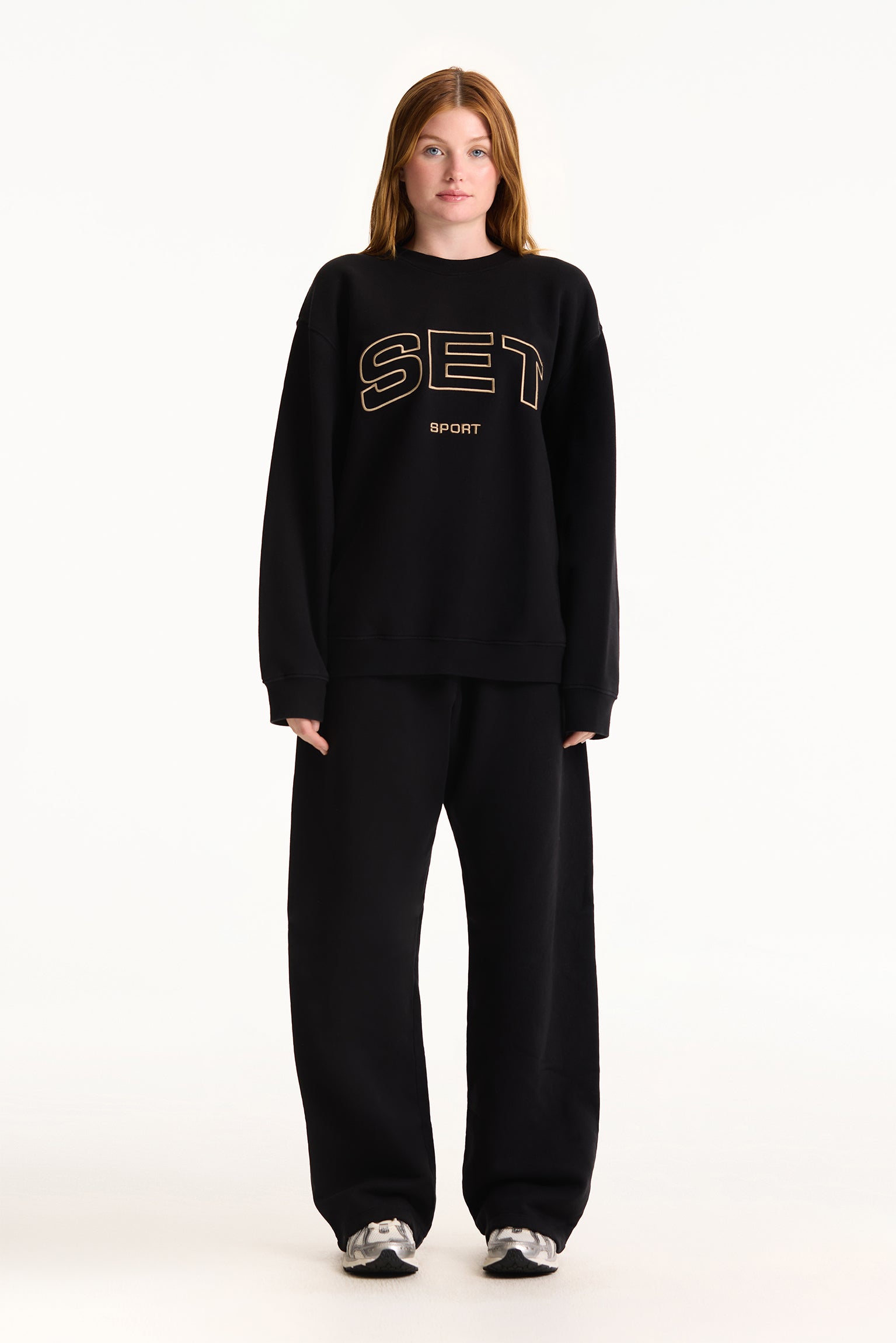 Person wearing a black outfit with 'SET' text on a white background