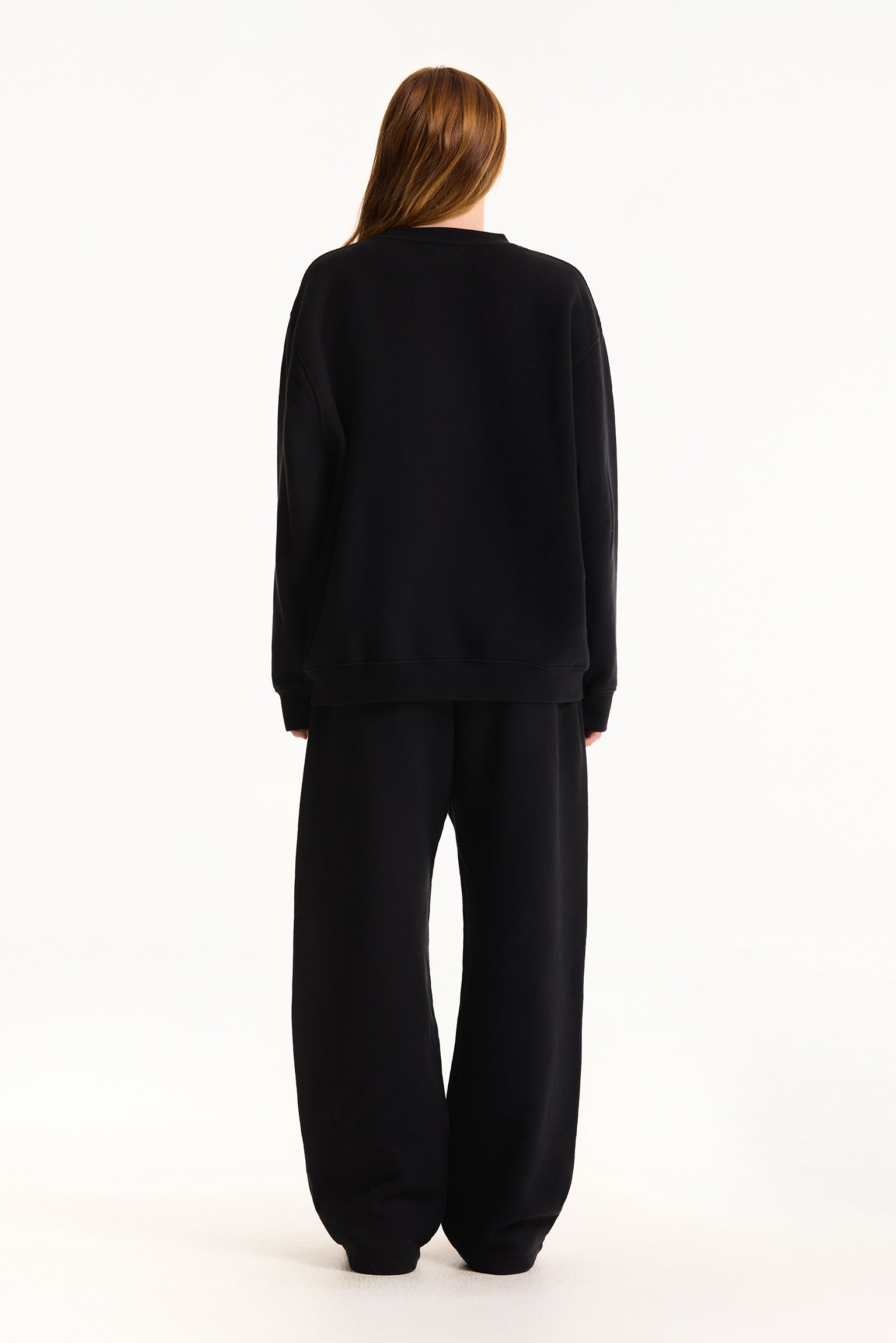 Person wearing a black outfit on a white background