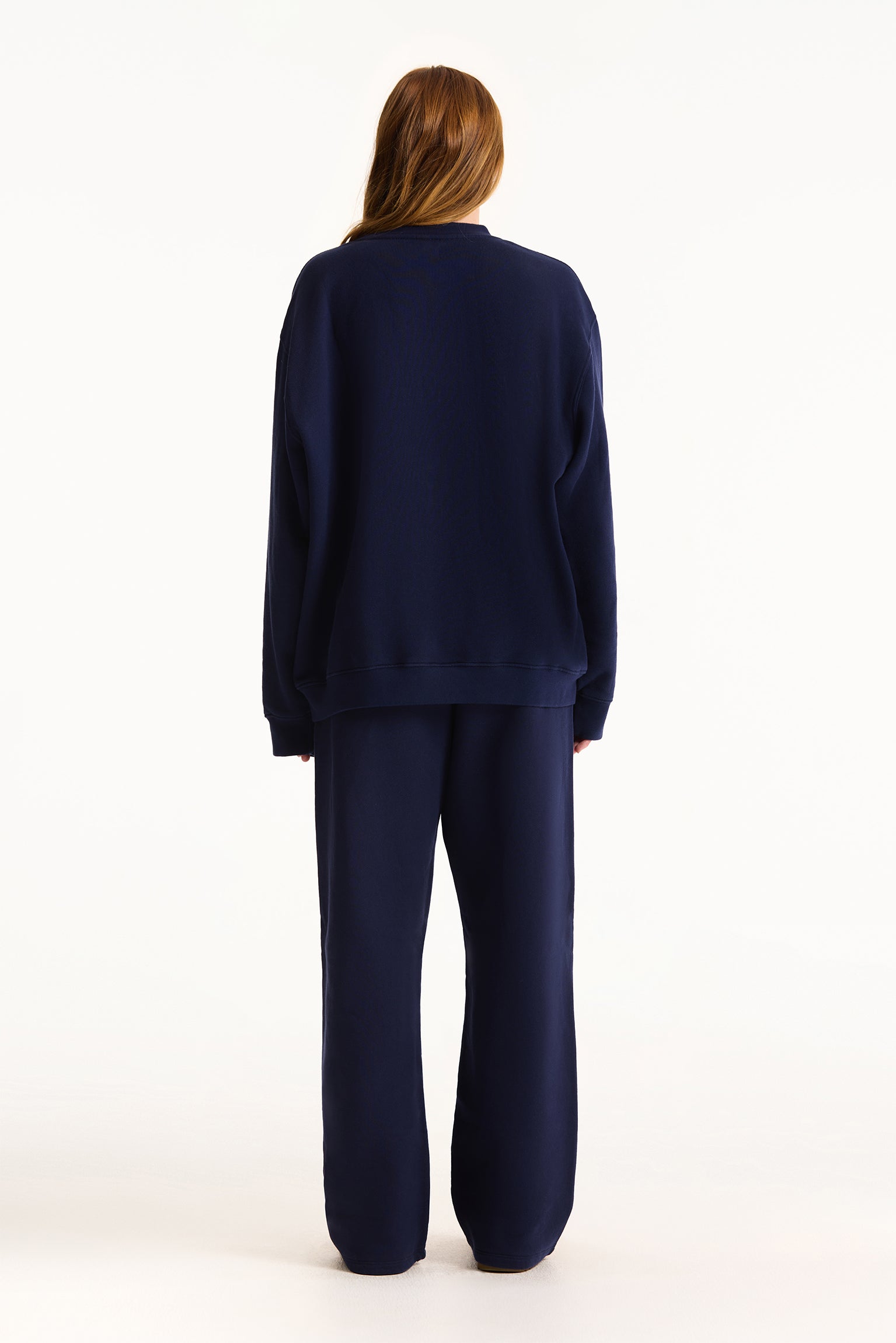 Person wearing a navy blue outfit on a white background