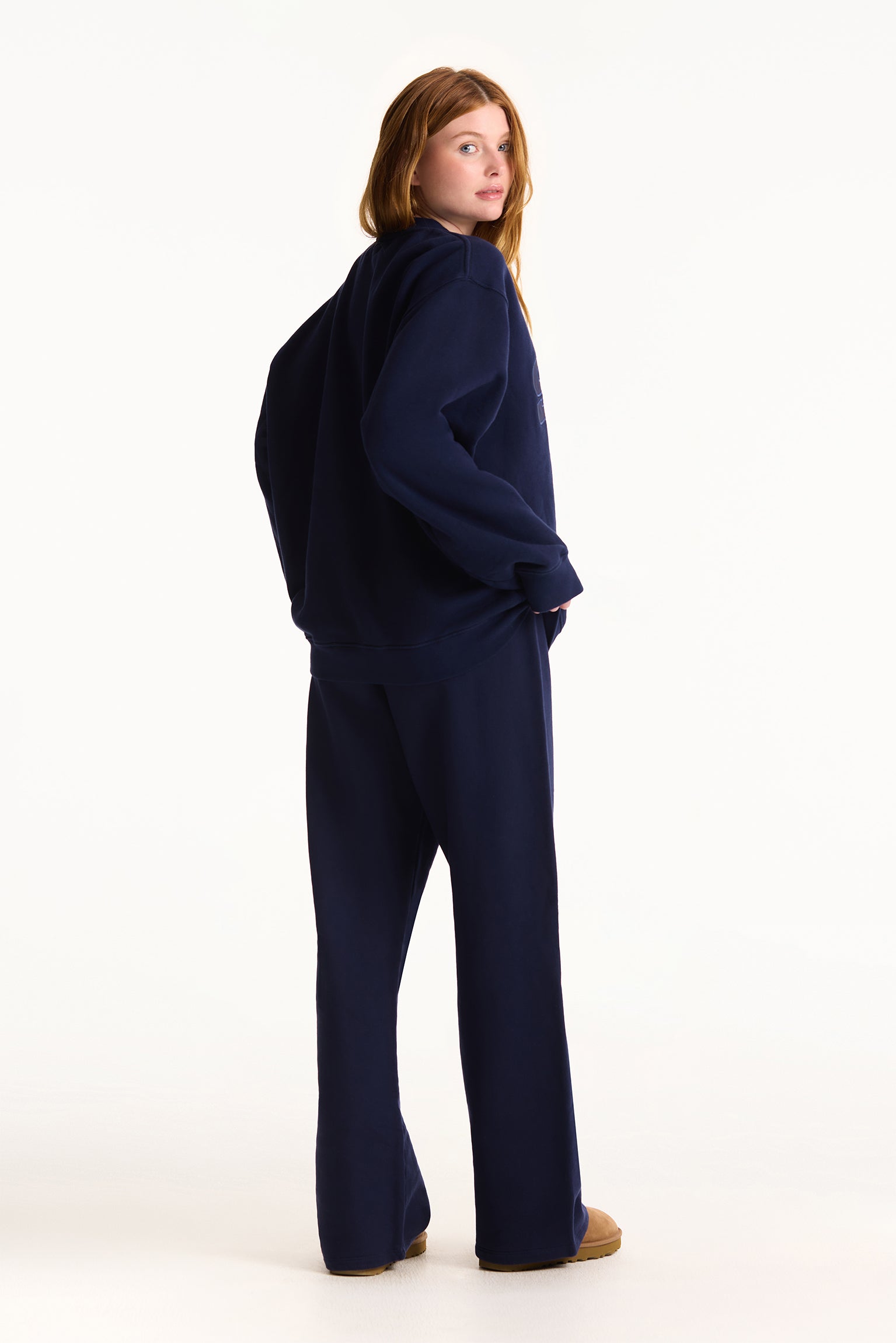 Person wearing a navy blue outfit on a white background