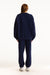 Person wearing a navy blue tracksuit on a white background