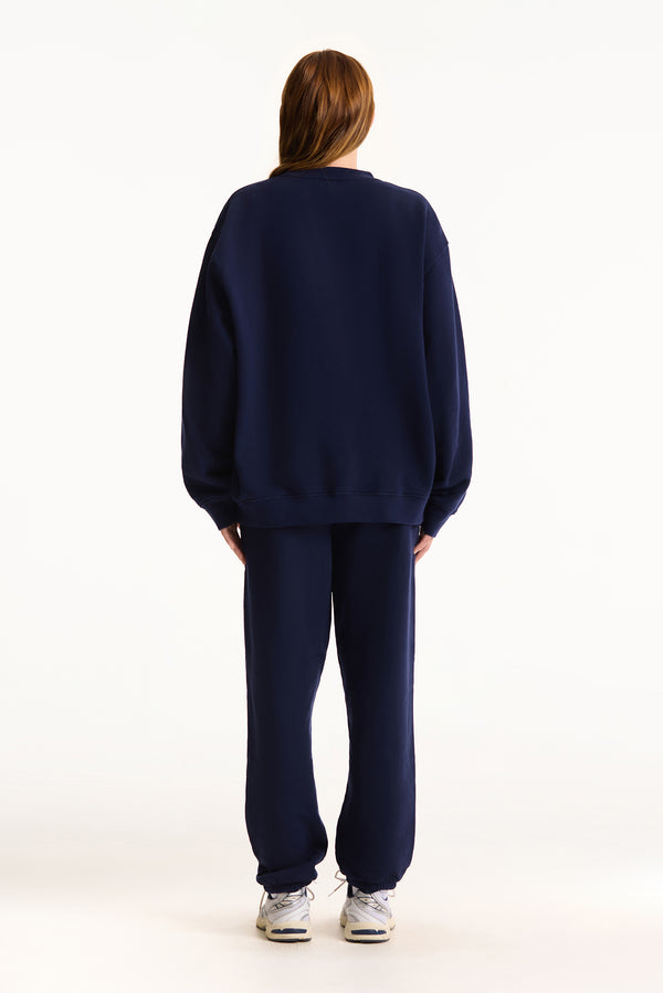 Person wearing a navy blue tracksuit on a white background