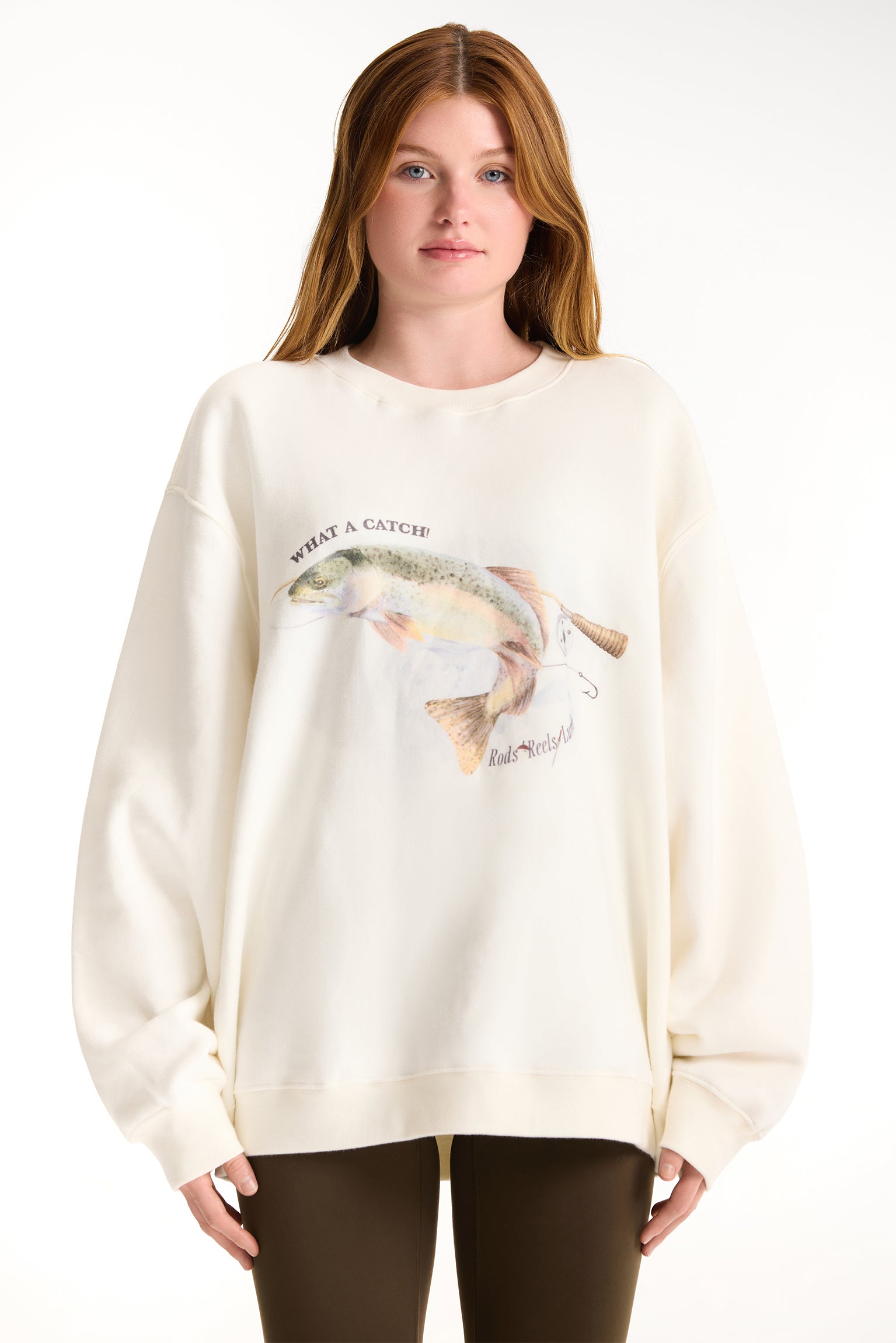 Woman wearing a cream-colored sweatshirt with a fish graphic and text on a white background <model-info>Dickey wears a size L and is 5’9”, 24” waist, 32” bust.</model-info>