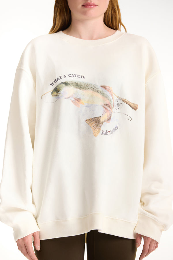 White sweatshirt with fish graphic and text worn by a person on a white background