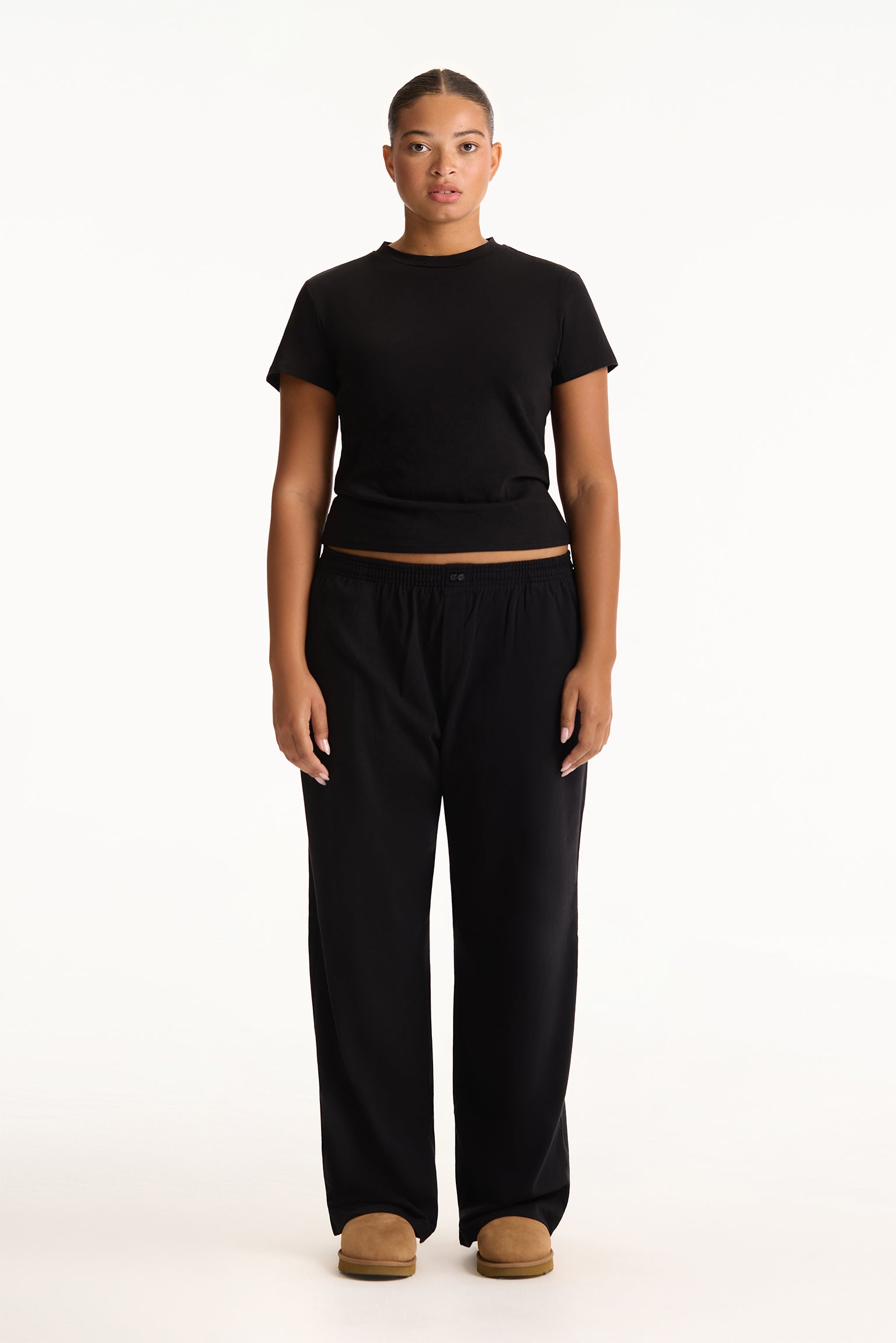 Person wearing a black t-shirt and black pants on a white background