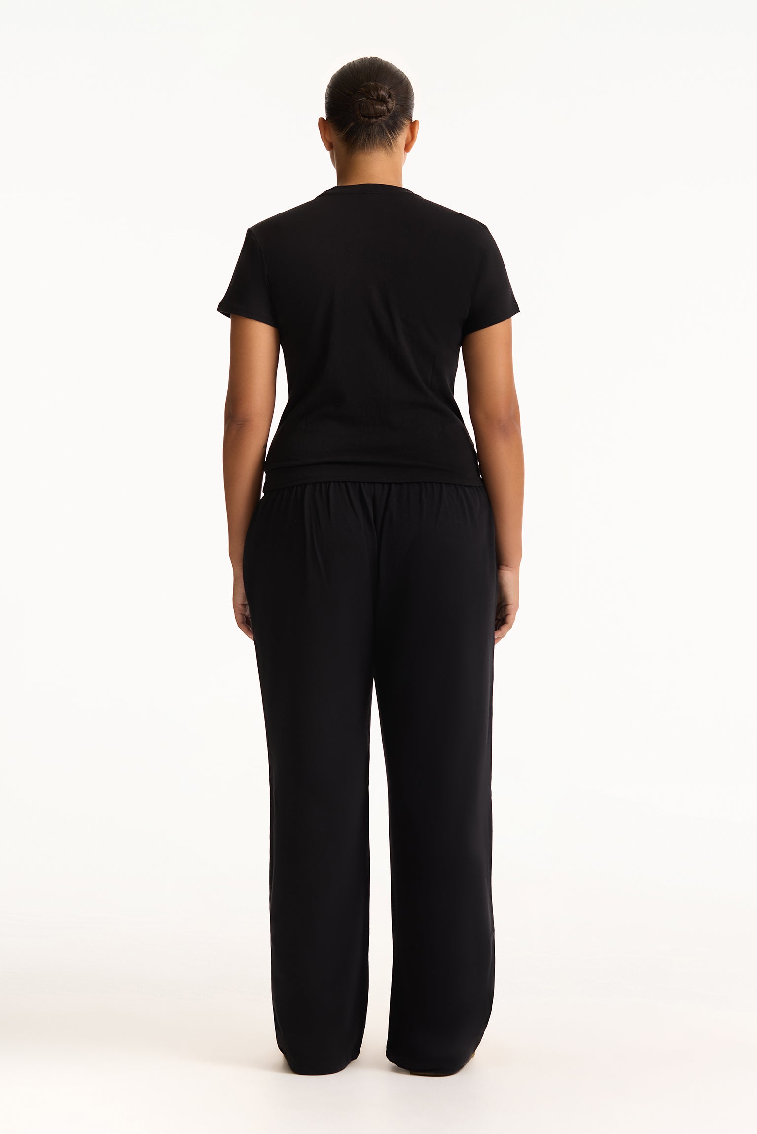 Person wearing a black outfit on a white background