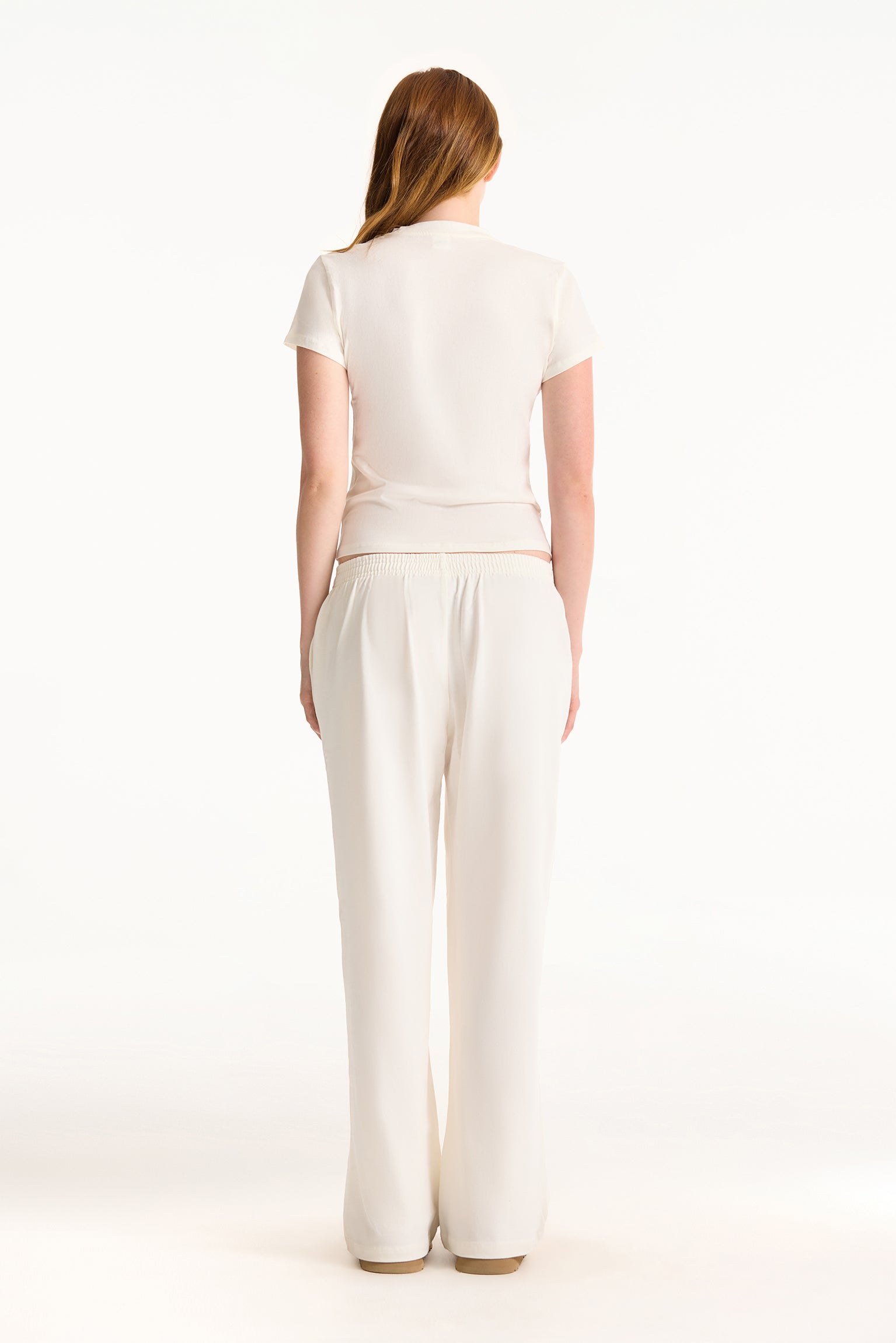 Woman wearing a white outfit on a white background