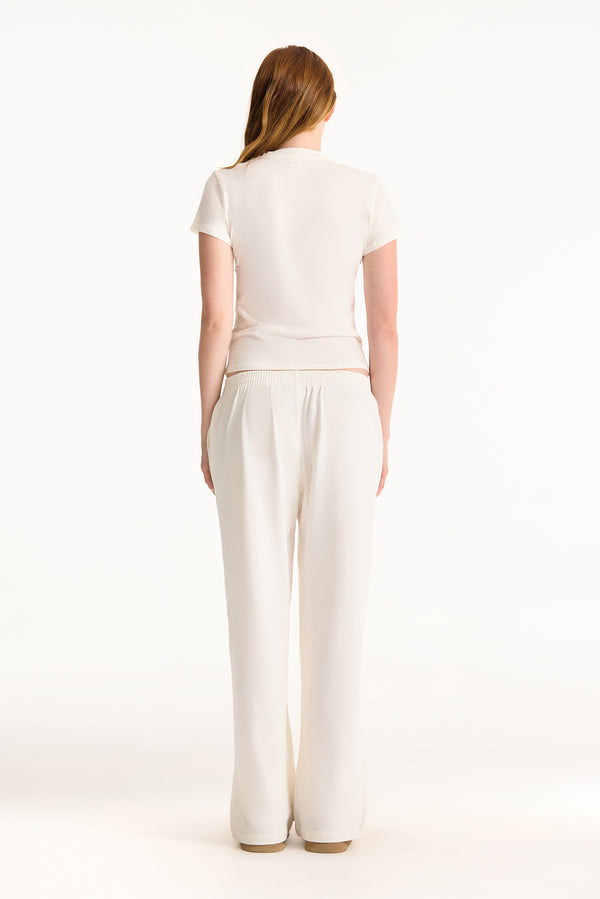 Woman wearing a white outfit on a white background