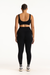 Person wearing a black sports bra and leggings set on a white background
