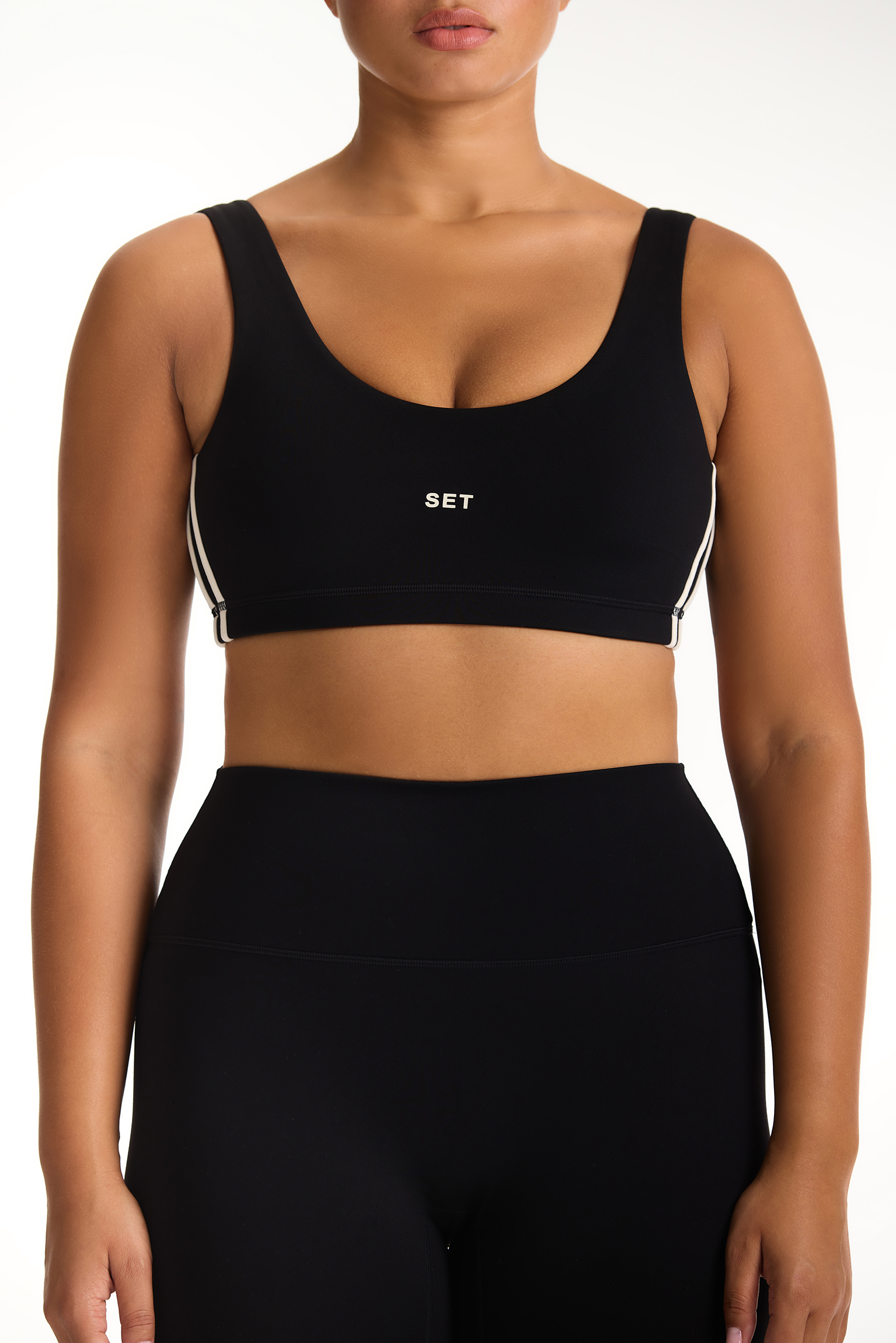 Black sports bra with 'SET' branding worn by a model on a white background