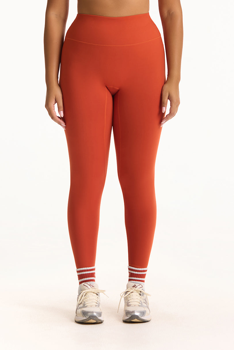Person wearing red leggings on a white background
