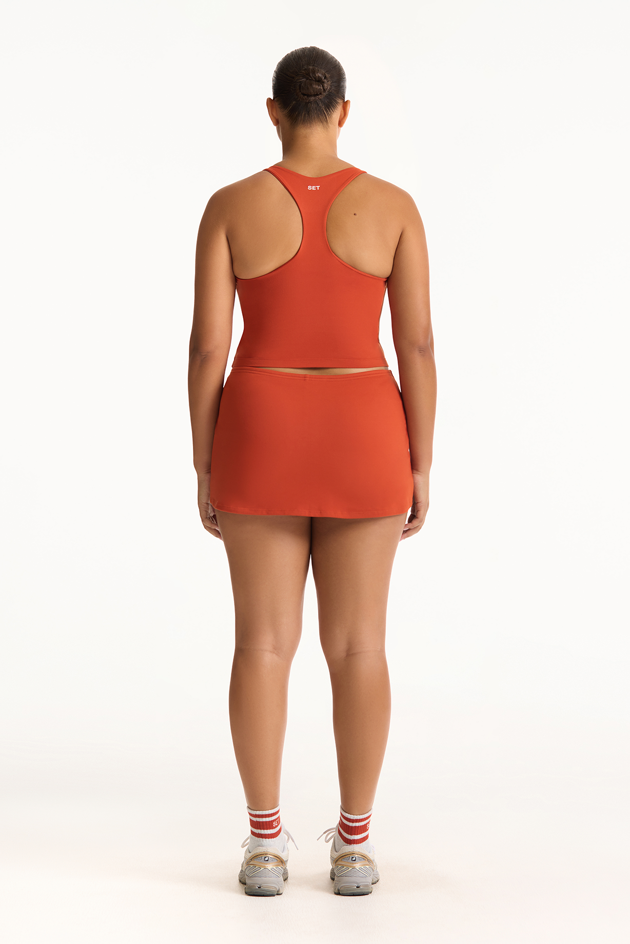 Person wearing an orange outfit on a white background