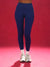 Person wearing blue leggings and white sneakers on a red background