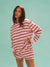 Woman wearing a pink and red striped outfit against a light blue background <model-info>Kushi wears a size XS and is 5'8, 24” waist, 32C bust.</model-info>