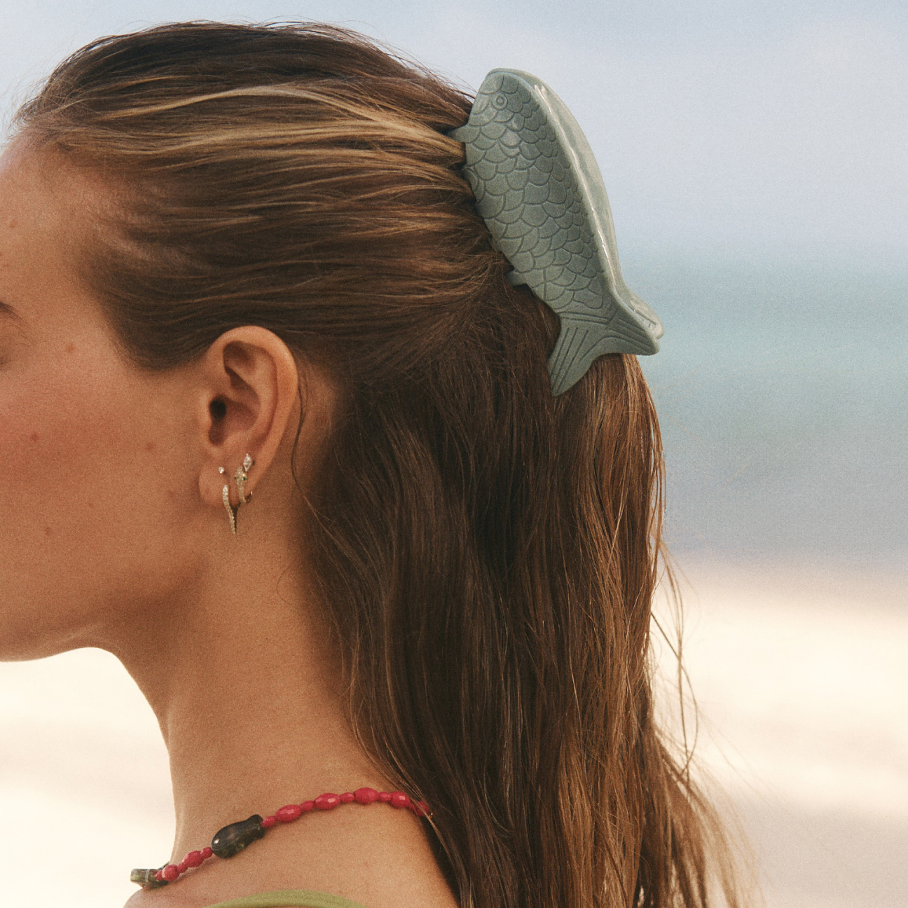 Woman with a fish-shaped hair clip in her hair against a blurred background