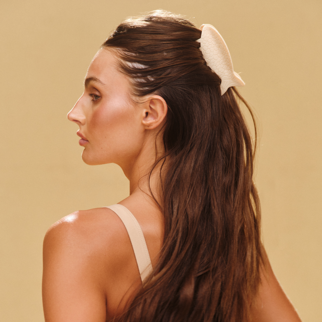 Woman faced sideways with a tan hair clip in her hair